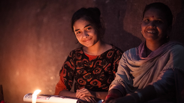 Two women beside warm candlelight