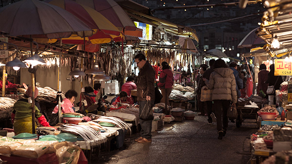 Produce stalls in a covered market at night
