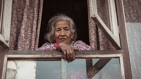 Older woman leaning out of an open window