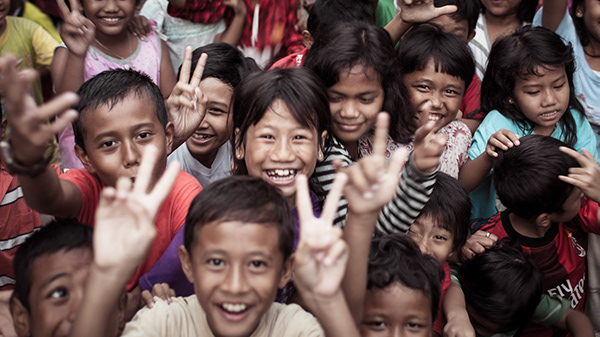 Group of smiling children waving at the camera
