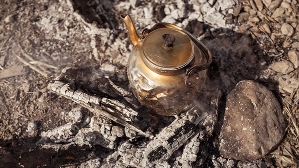 Brass kettle resting over a fire