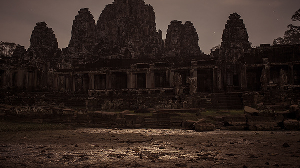 Ancient stone temple silhouetted in low light