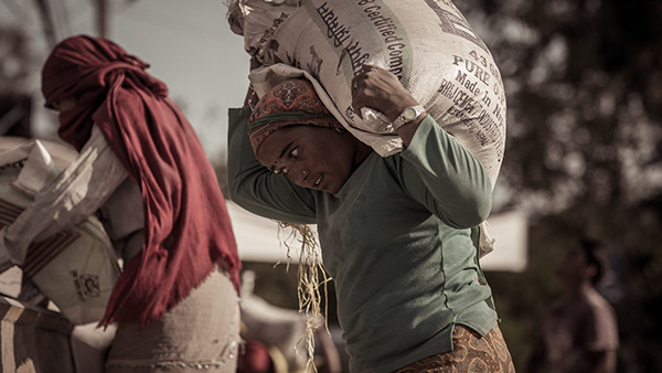 Person carrying bundled goods through a crowded street
