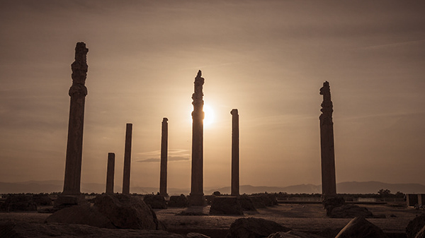 Tall stone columns silhouetted against the evening sky