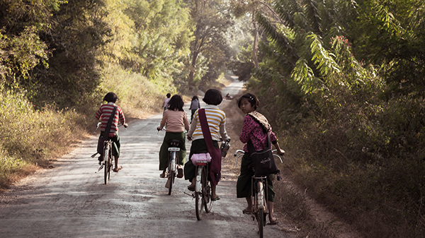 Children walking along a path surrounded by greenery