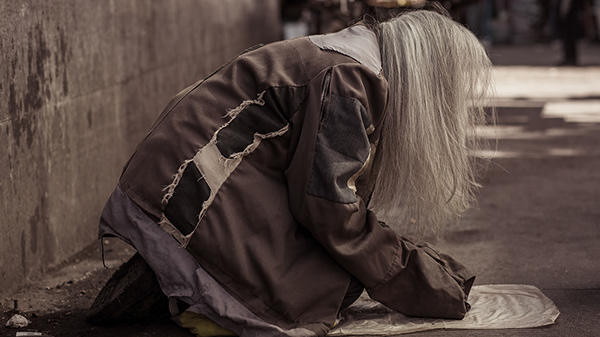 Long-haired person leaning over a plate beside a wall