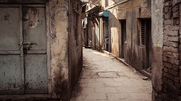 Sunlit alley lined with weathered buildings