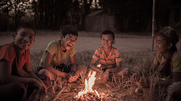 People gathered around a small fire at night
